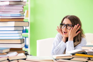 Sınavlara bir sürü kitapla hazırlanan genç kız öğrenci. 