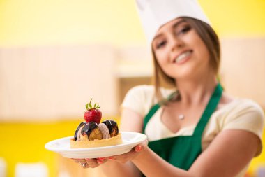 Genç aşçı mutfakta kek pişiriyor.