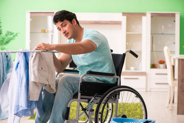 Инвалид на инвалидной коляске стирает белье — стоковое фото