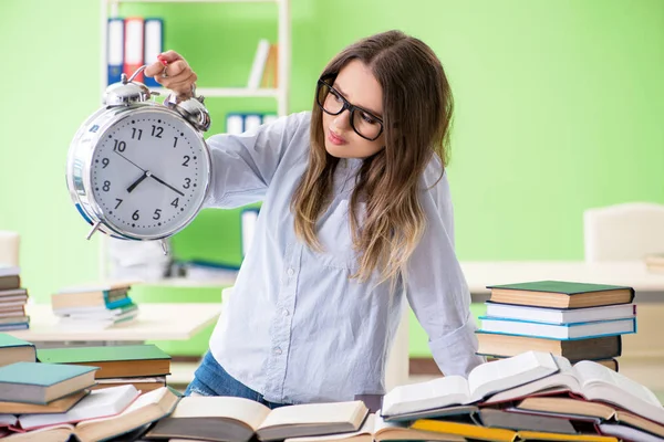 Ung kvinnlig student förbereder sig för tentor med många böcker i tid — Stockfoto