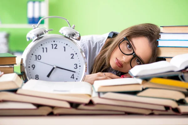 Jeune étudiante se préparant aux examens avec de nombreux livres à temps — Photo