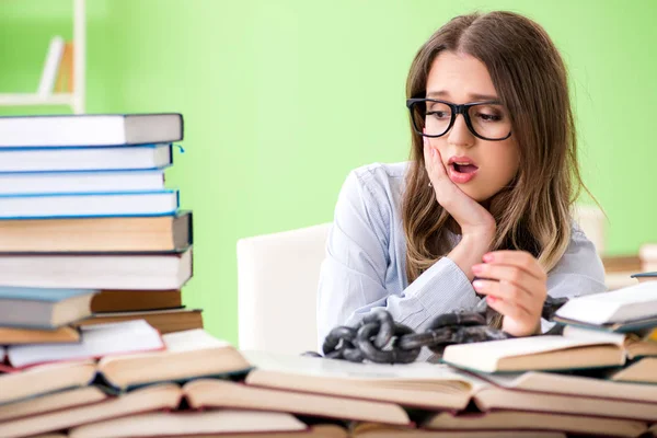 Joven estudiante encadenada al escritorio y preparándose para los exámenes —  Fotos de Stock