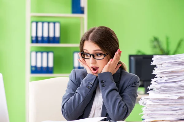 Jonge vrouwelijke werknemer zeer druk met doorlopend papierwerk — Stockfoto