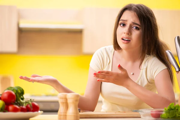 Jovem mulher preparando salada em casa na cozinha — Fotografia de Stock