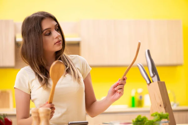 Jovem mulher preparando salada em casa na cozinha — Fotografia de Stock