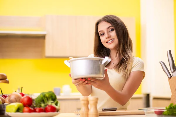 Young woman cooking soup in kitchen at home — Stock Photo, Image