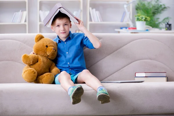 Kleine jongen die thuis boeken leest — Stockfoto