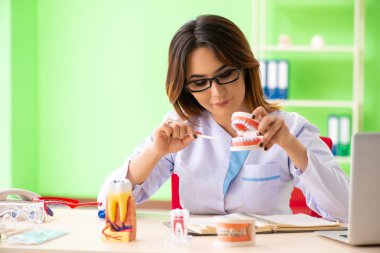 Diş implantı üzerinde çalışan kadın dişçi.