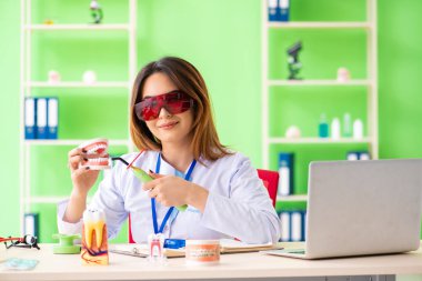 Diş implantı üzerinde çalışan kadın dişçi.