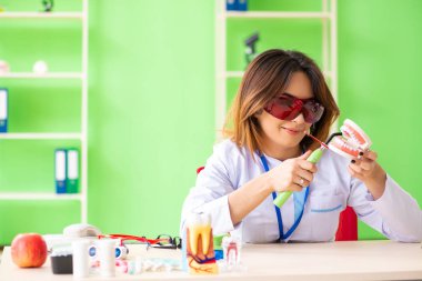 Diş implantı üzerinde çalışan kadın dişçi.