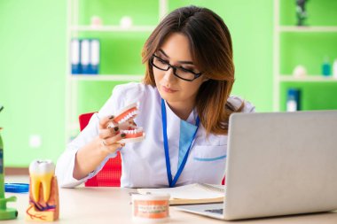 Diş implantı üzerinde çalışan kadın dişçi.