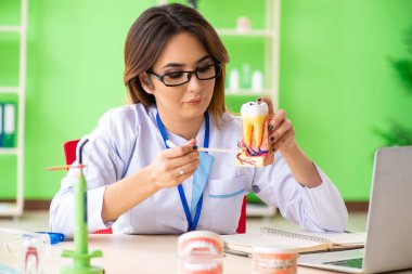 Diş implantı üzerinde çalışan kadın dişçi.