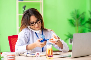 Diş implantı üzerinde çalışan kadın dişçi.