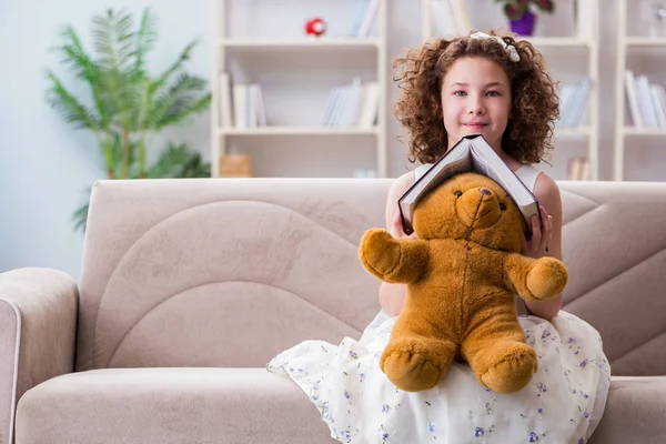 Pequeña chica bonita leyendo libros en casa — Foto de Stock