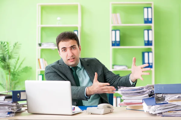 Бизнесмен злится из-за чрезмерной работы, сидя в офисе — стоковое фото