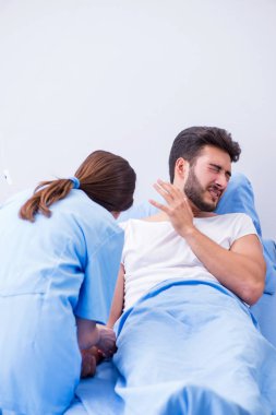 Kadın doktor erkek hastayı hastanede muayene ediyor.
