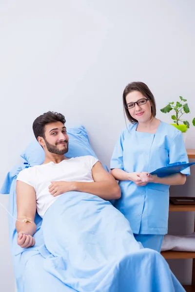 Kvinna läkare undersöker manlig patient på sjukhus — Stockfoto