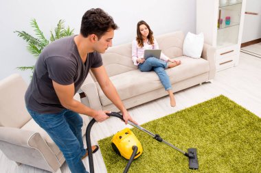 Genç bir aile evde temizlik yapıyor.