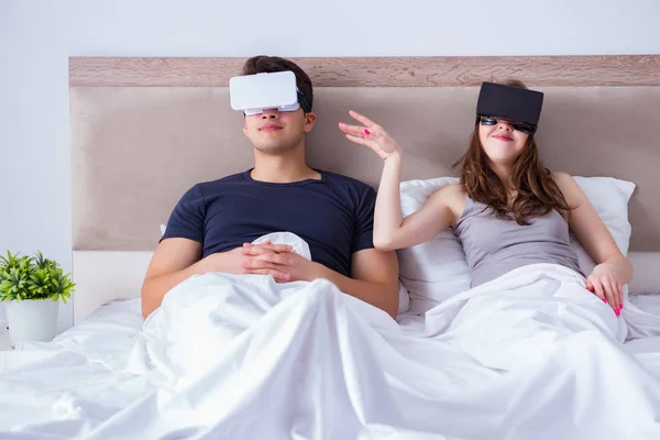 Esposa e marido com óculos de realidade virtual na cama — Fotografia de Stock