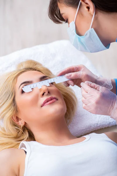 Kobieta okulista bada pacjentkę w oczodołach. — Zdjęcie stockowe