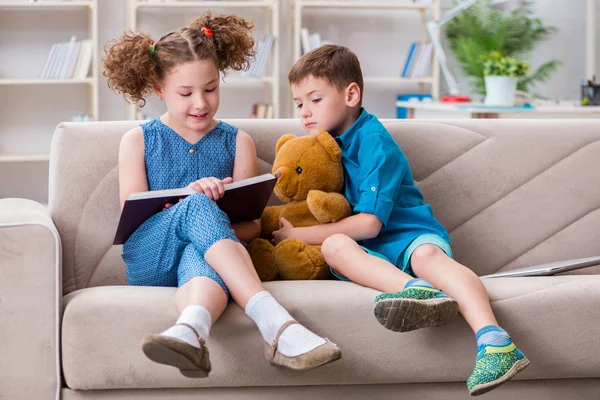 두 자녀가 집에서 책을 읽고 있다 — 스톡 사진