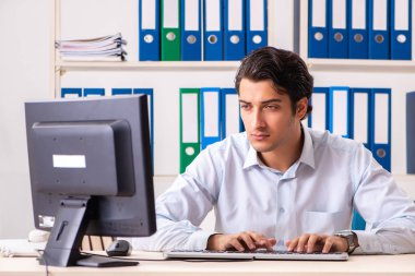 Genç yakışıklı işadamı ofiste çalışıyor.