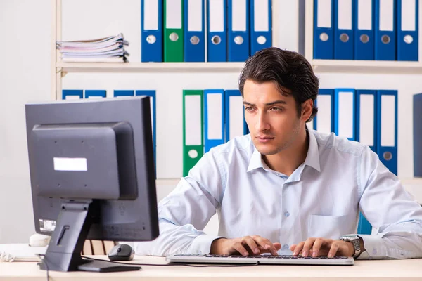 Genç yakışıklı işadamı ofiste çalışıyor.