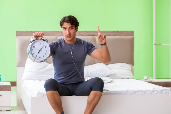 Joven hombre guapo haciendo ejercicios matutinos en la habitación del hotel — Foto de Stock