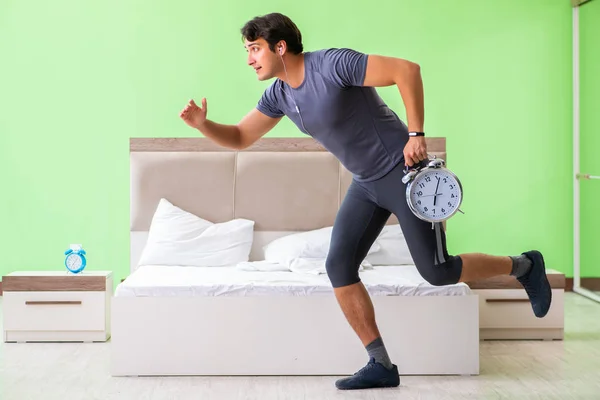 Joven hombre guapo haciendo ejercicios matutinos en la habitación del hotel — Foto de Stock