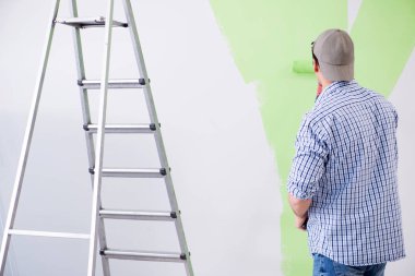 Genç ressam evde tadilat yapıyor. 