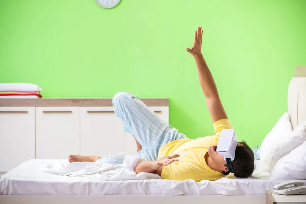 Giovane uomo con occhiali virtuali in camera da letto — Foto Stock