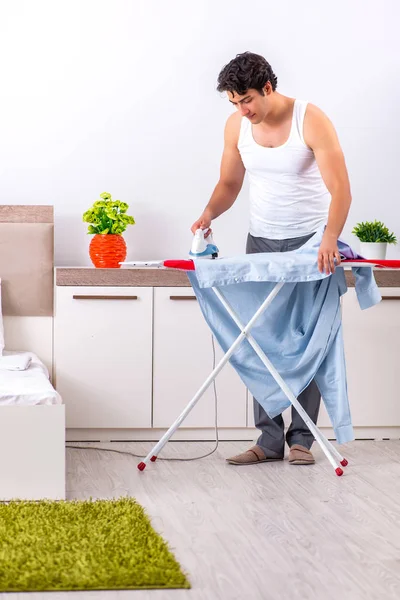 Young man ironing in the bedroom — Stock Photo, Image