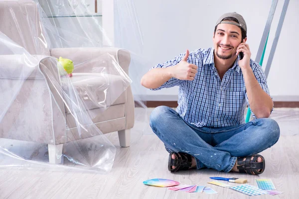 Young man contractor choosing color from rainbow — Stock Photo, Image