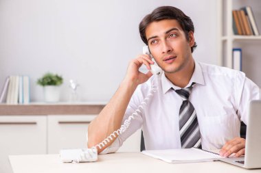 Genç çağrı merkezi operatörü telefonda konuşuyor.