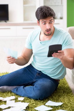 Genç adam kişisel finans ve faturalarla boğuşuyor.