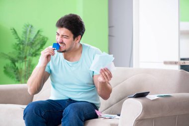 Genç adam kişisel finans ve faturalarla boğuşuyor.