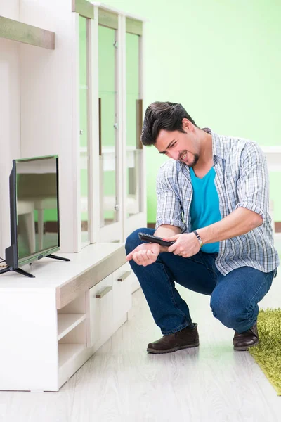 Молодий чоловік чоловік ремонтує телевізор вдома — стокове фото