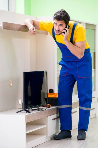 Mannelijke professionele serviceman die thuis tv repareert — Stockfoto