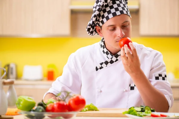 Joven cocinero profesional preparando ensalada en la cocina —  Fotos de Stock