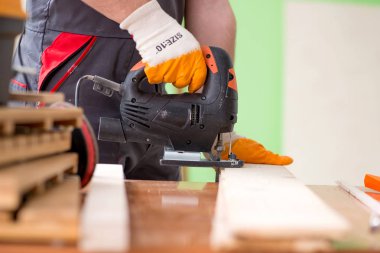 Atölyede çalışan genç bir marangoz. 