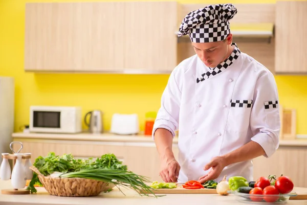 Young professional cook preparing salad at kitchen — Stock Photo, Image