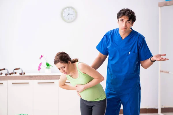 Έγκυος γυναίκα κάνει σωματική άσκηση με εκπαιδευτή — Φωτογραφία Αρχείου