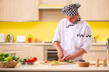 Genç profesyonel aşçı mutfakta salata hazırlıyor.