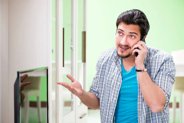 Joven marido reparando tv en casa — Foto de Stock