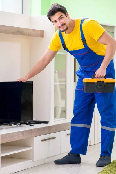 Erkek profesyonel tamirci evde televizyon tamir ediyor. — Stok fotoğraf