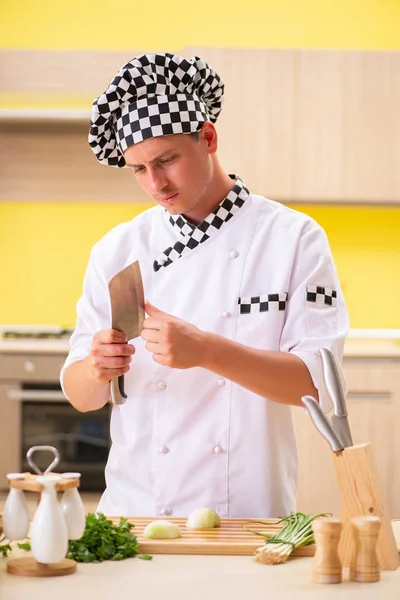 Jovem cozinheiro profissional preparando salada na cozinha — Fotografia de Stock