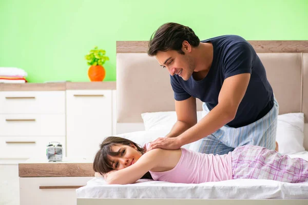 Mann tut Massage für seine Frau im Schlafzimmer — Stockfoto