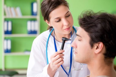 Tıbbi muayene sırasında kadın doktor hastaların kulaklarını kontrol ediyor. 