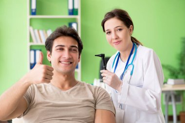 Tıbbi muayene sırasında kadın doktor hastaların kulaklarını kontrol ediyor. 