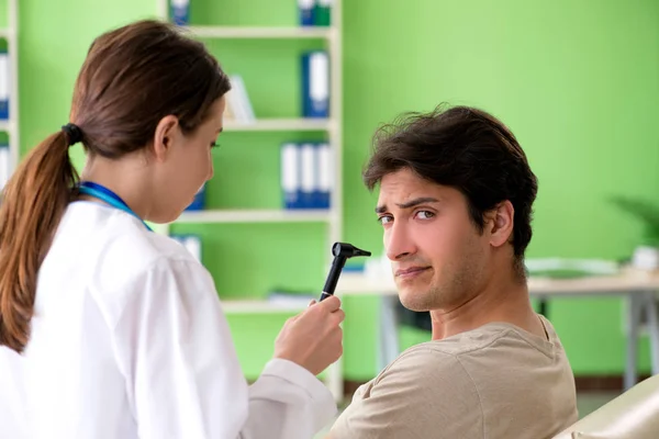 Médica verificando pacientes ouvido durante o exame médico — Fotografia de Stock